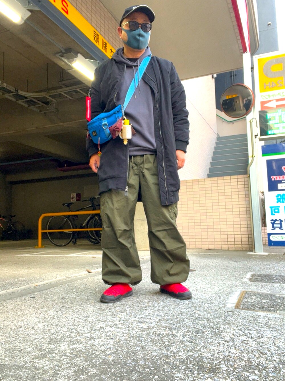 グリーン系のカーゴパンツ、ブルー系のボディバッグ/ウエストポーチ、ブラック系のMA-1を着用したメンズの春コーディネートの2枚目の写真