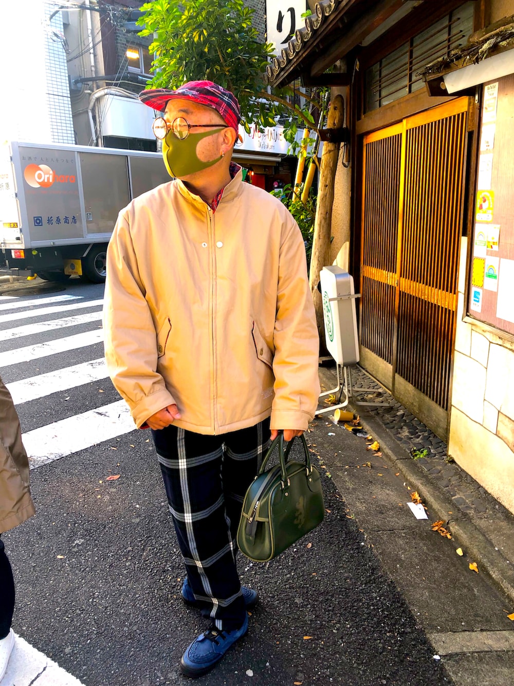 ベージュ系のブルゾン、ブルー系のスラックス、ブルー系のスニーカーを着用したメンズの秋コーディネートの2枚目の写真