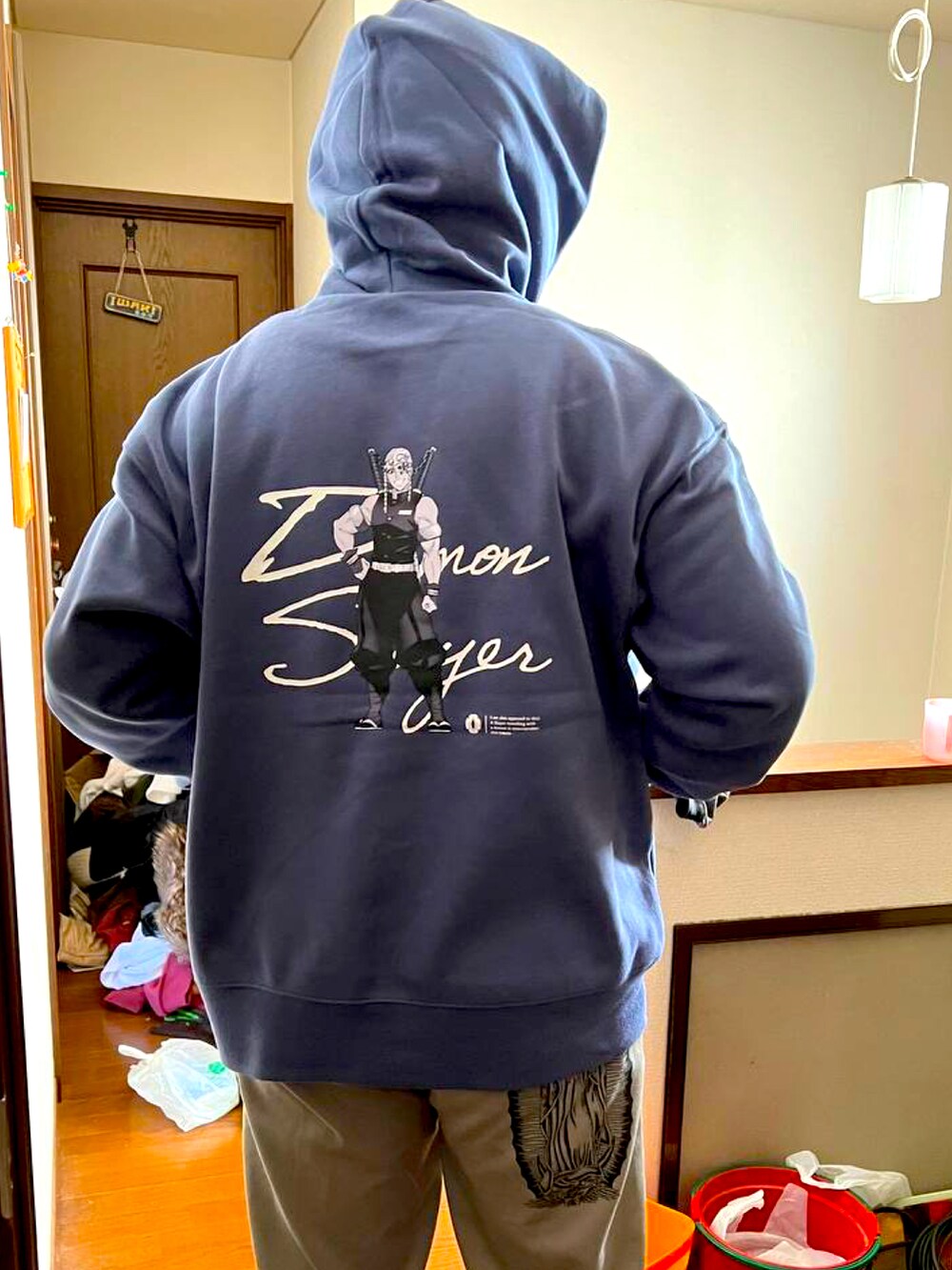 ベージュ系のトートバッグ、グリーン系のナイロンジャケット、グレー系のチノパンツを着用したメンズの冬コーディネートの2枚目の写真