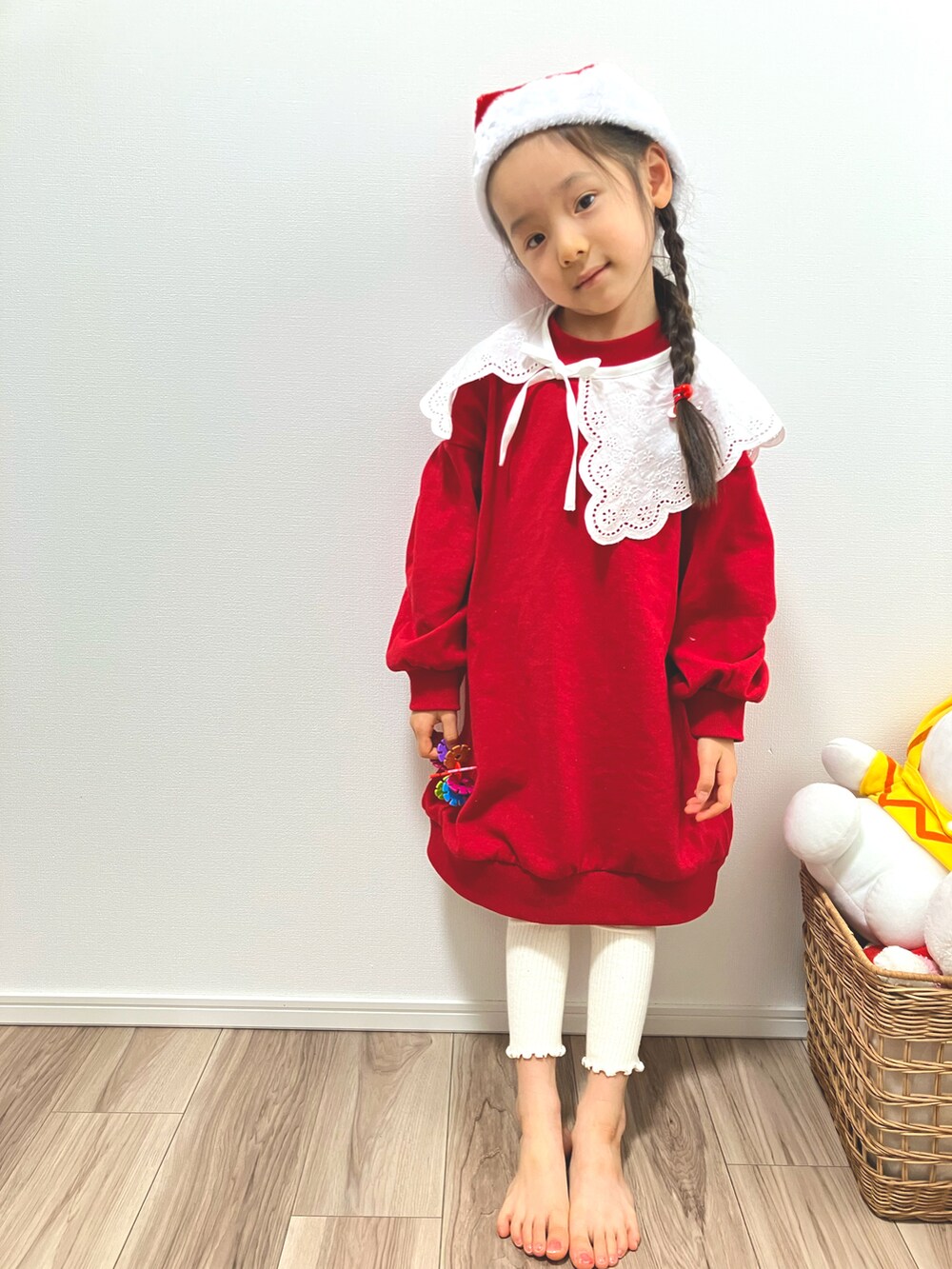 レッド系のワンピース、ホワイト系の付け襟、ホワイト系のレギンス/スパッツを着用したキッズの冬コーディネートの2枚目の写真