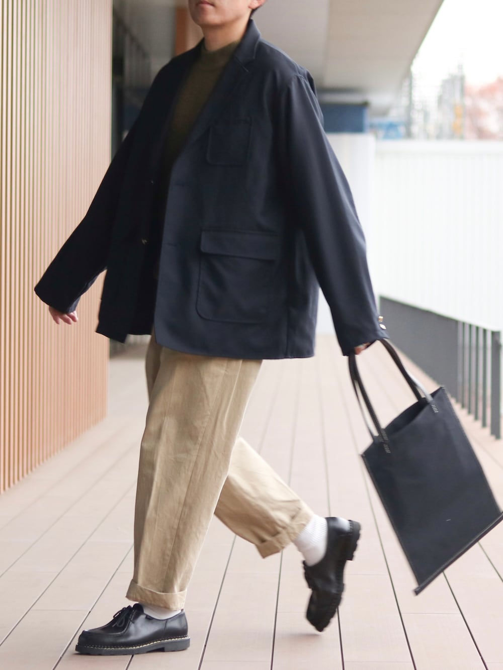 ブルー系のテーラードジャケット、グリーン系のニット/セーター、ベージュ系のチノパンツを着用したメンズの秋コーディネートの3枚目の写真