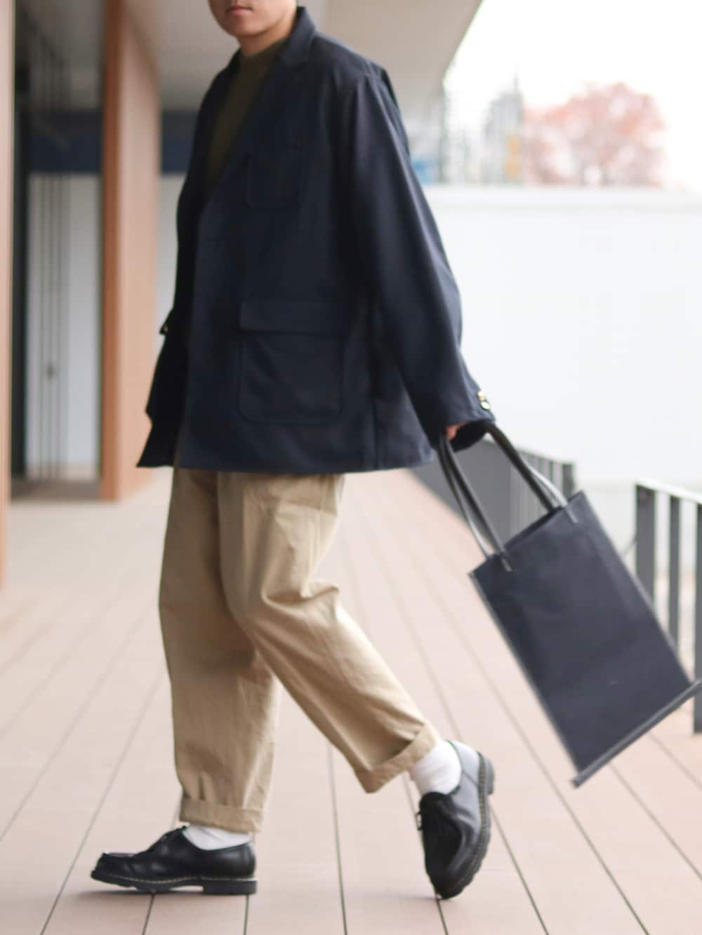 ブルー系のテーラードジャケット、グリーン系のニット/セーター、ベージュ系のチノパンツを着用したメンズの秋コーディネートの2枚目の写真