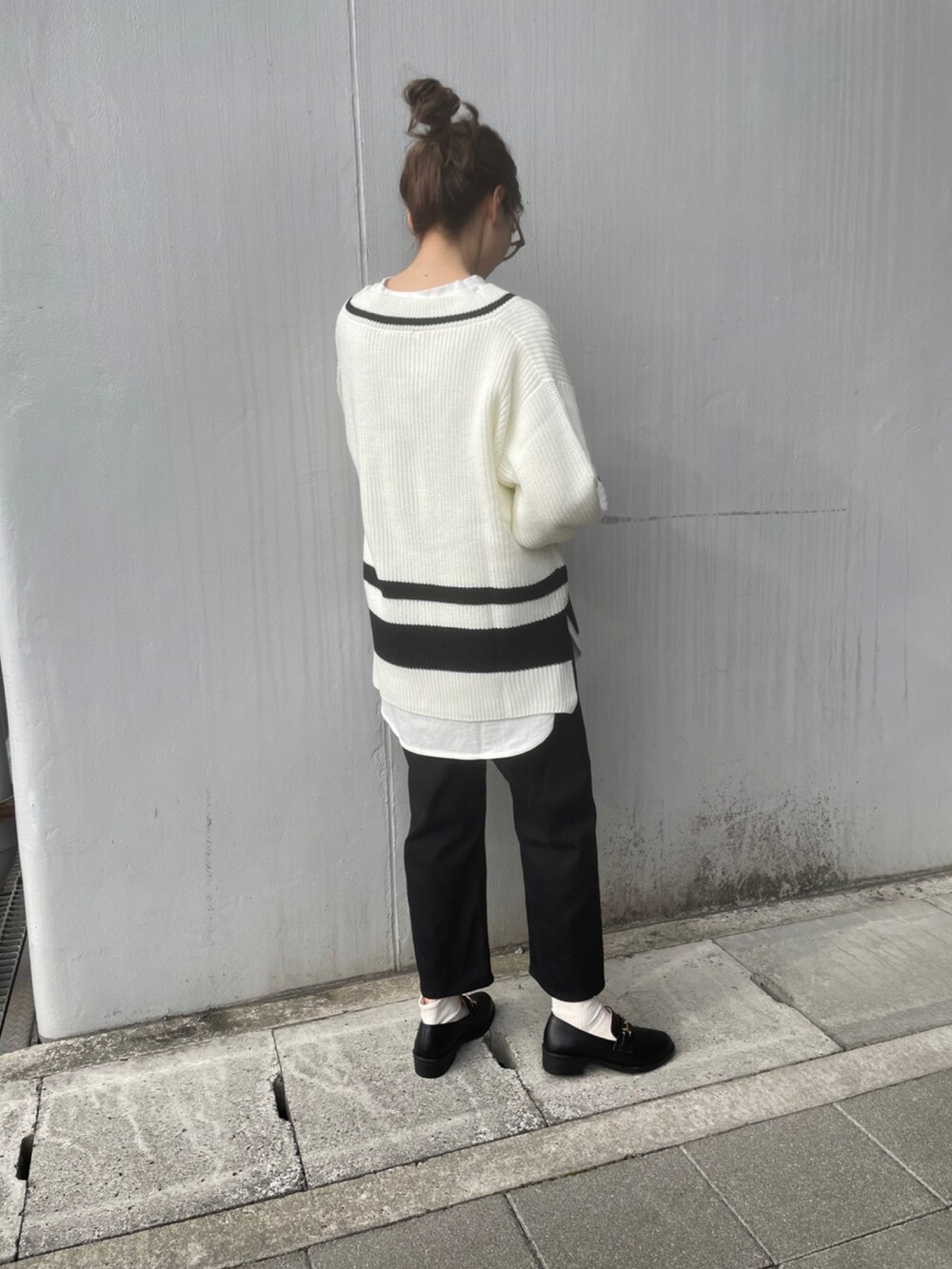 ホワイト系のニット/セーター、ブラック系のパンツ、ブラック系のローファーを着用したレディースの冬コーディネートの3枚目の写真
