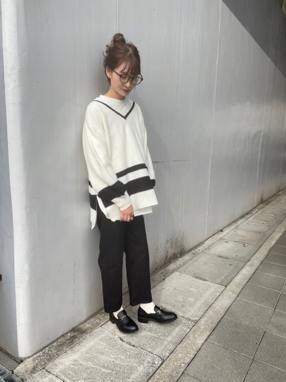 ホワイト系のニット/セーター、ブラック系のパンツ、ブラック系のローファーを着用したレディースの冬コーディネートの4枚目の写真