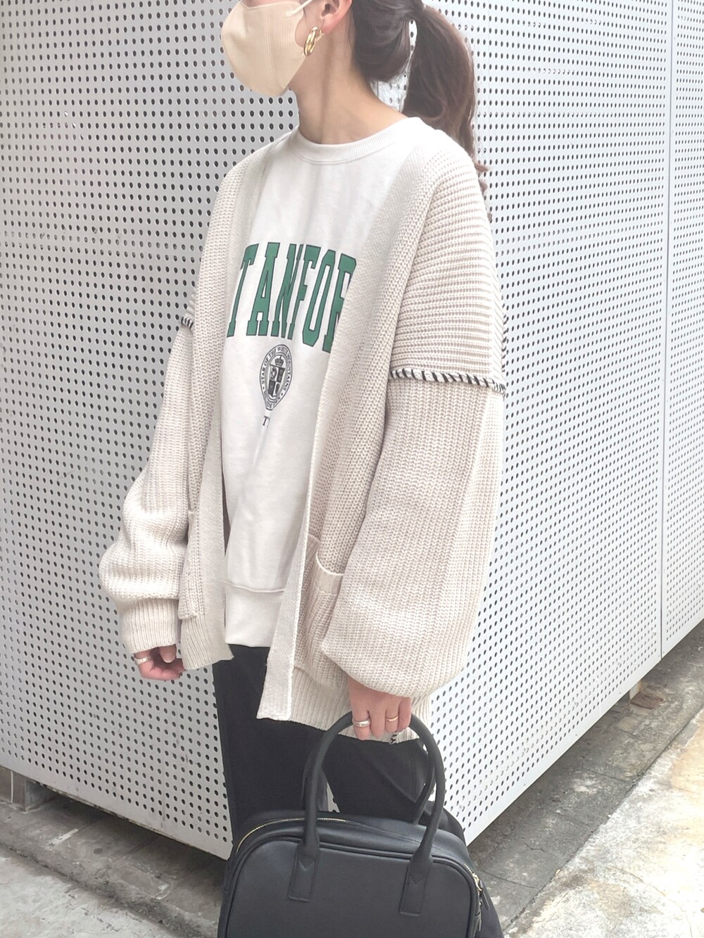 ベージュ系のカーディガン/ボレロ、ブラック系のボストンバッグ、ブラック系のブーツを着用したレディースの秋コーディネートの3枚目の写真