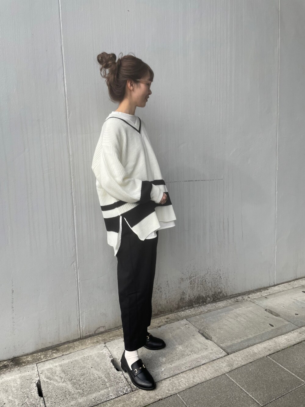 ホワイト系のニット/セーター、ブラック系のパンツ、ブラック系のローファーを着用したレディースの冬コーディネートの2枚目の写真