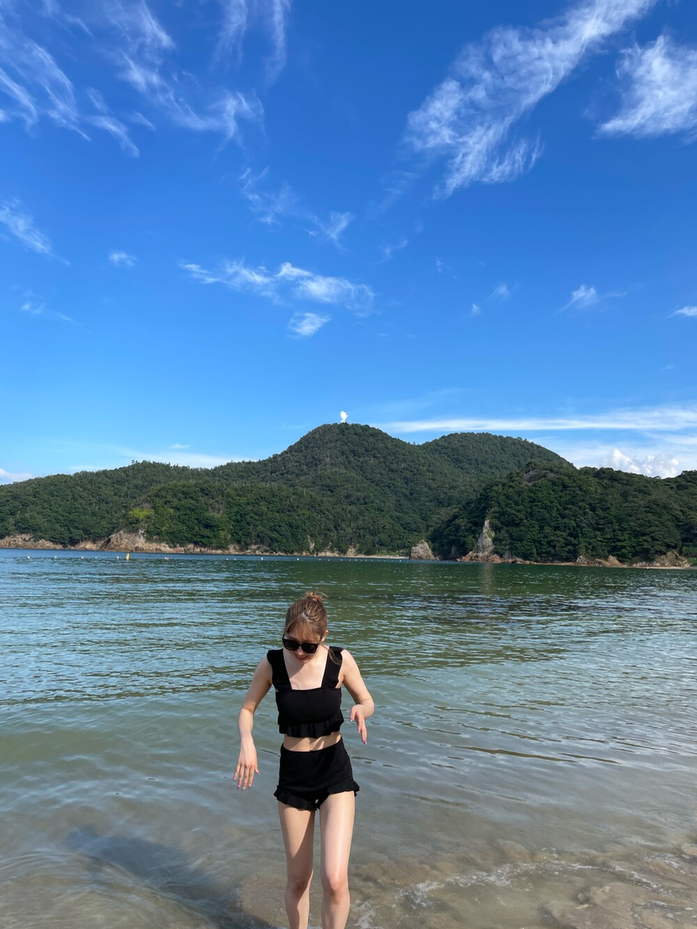 ブラック系の水着を着用したレディースの夏コーディネートの2枚目の写真