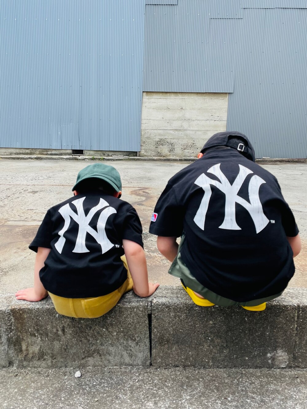 ブラック系のTシャツ/カットソー、ブラック系のサンダル、グリーン系のパンツを着用したキッズの春コーディネートの2枚目の写真