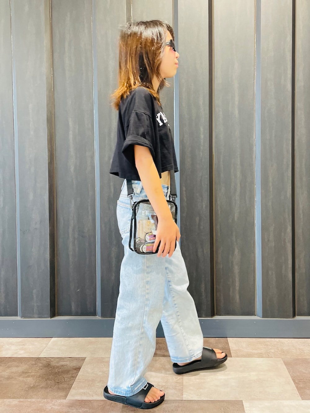 ブラック系のTシャツ/カットソー、ブルー系のデニムパンツ、ブラック系のサンダルを着用したキッズの夏コーディネートの2枚目の写真