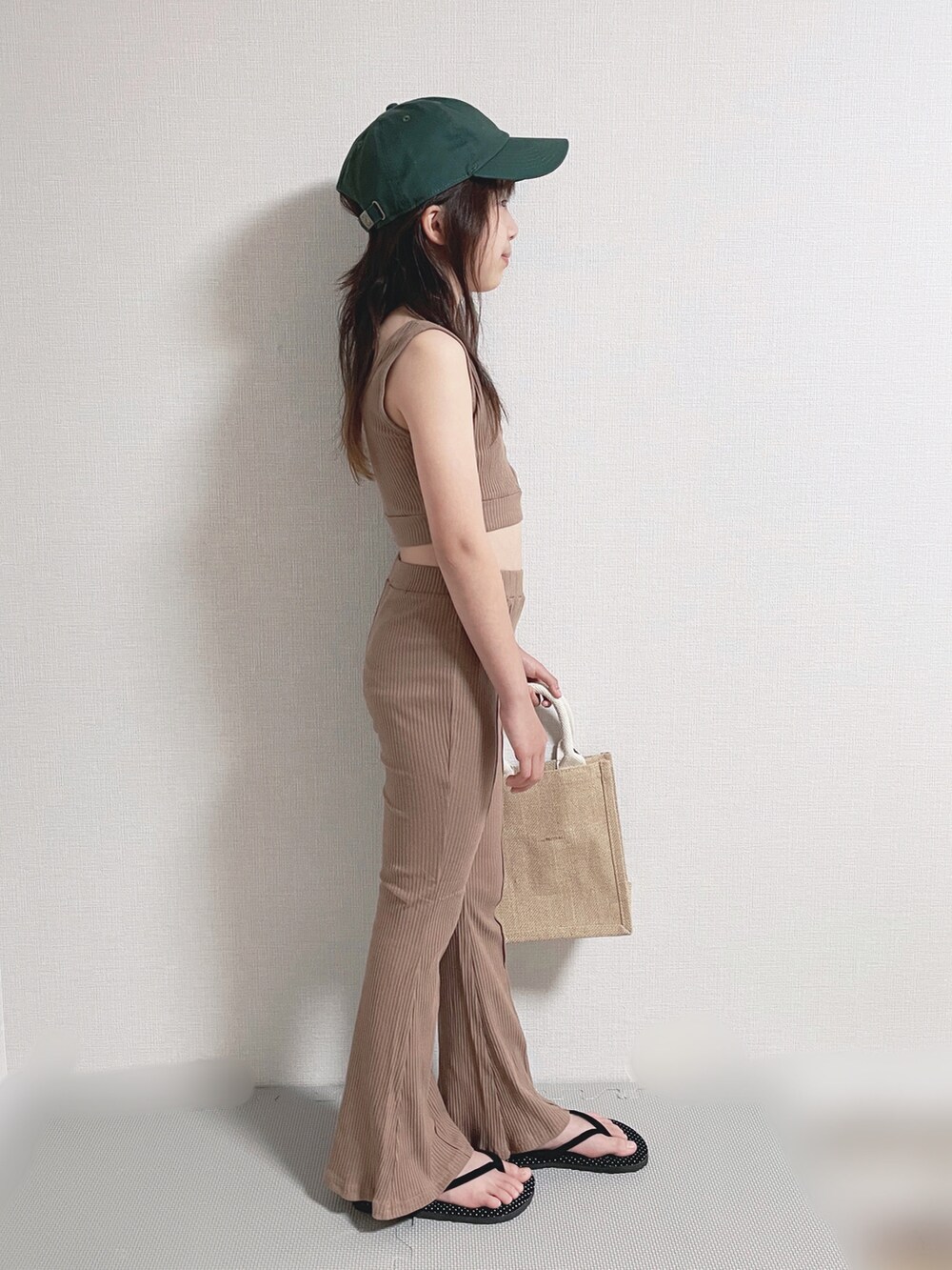 グリーン系のセットアップ、ホワイト系のシャツ/ブラウス、ベージュ系のバッグを着用したキッズの春コーディネートの2枚目の写真