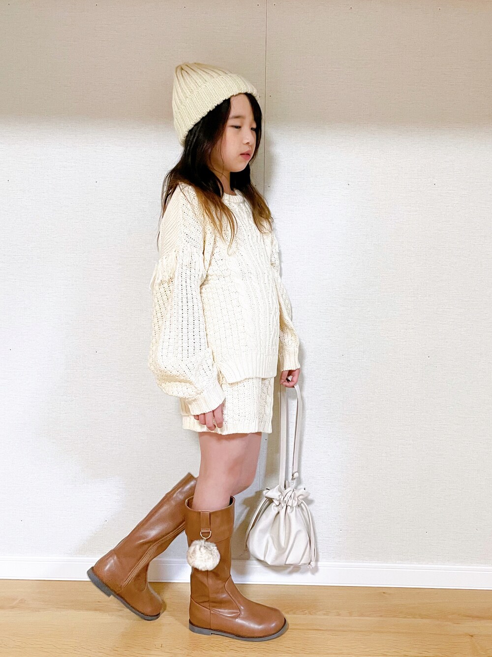「セットアップ、ブーツ、レザー、ニット帽、ショートパンツ、ケーブルニット、冬コーデ、ロングブーツ、白ニット、キッズコーデ、巾着バッグ、白パンツ、ホワイトコーデ、シンプルコーデ、小学生」｜「BREEZEのケーブルフリンジニット（ニット/セーター、ホワイト系）」を使った、naaaさん（キッズ・130cm）の冬コーディネートの2枚目の写真