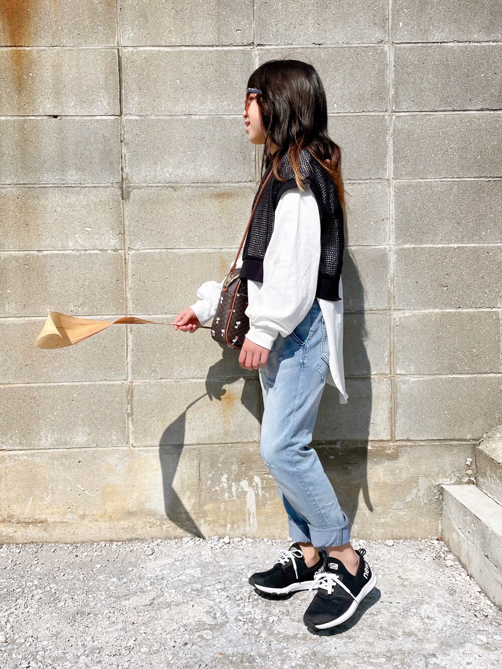 ブラック系のTシャツ/カットソー、ブルー系のその他パンツ、ブラウン系のボストンバッグを着用したキッズの春コーディネートの3枚目の写真