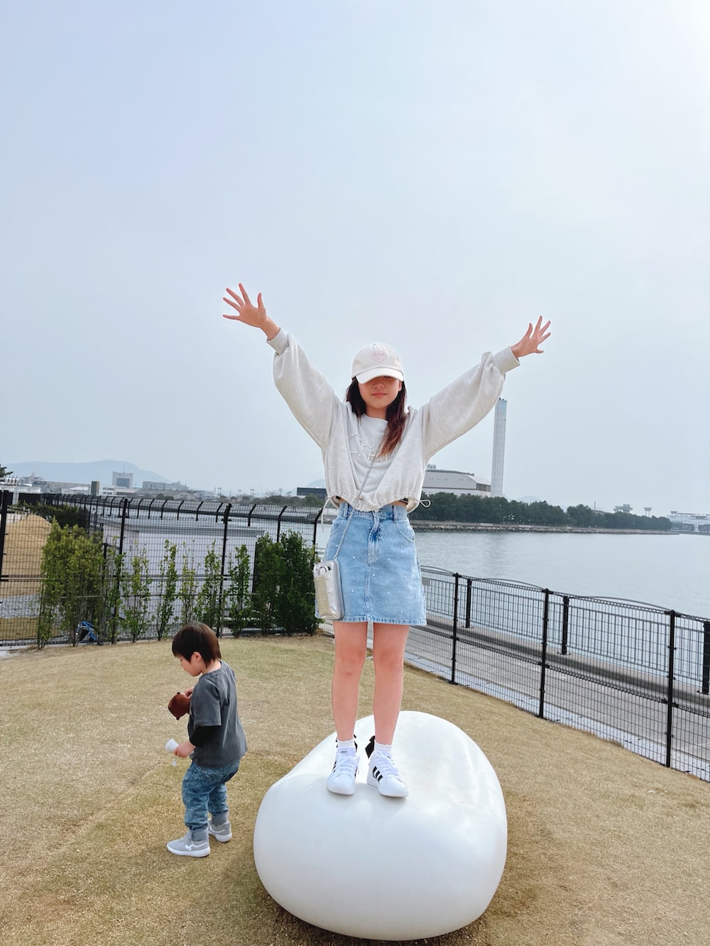 ホワイト系のトップス、ブルー系のスカート、シルバー系のバッグを着用したキッズの春コーディネートの4枚目の写真