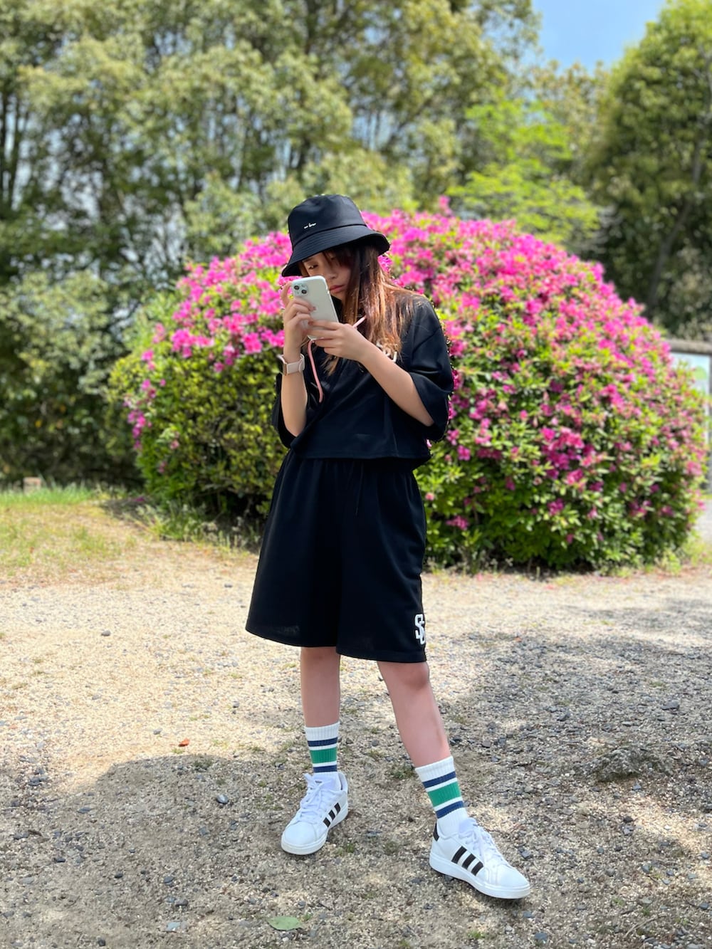 ブラック系のセットアップ、ホワイト系のスニーカー、ブラック系のハットを着用したキッズの春コーディネートの3枚目の写真