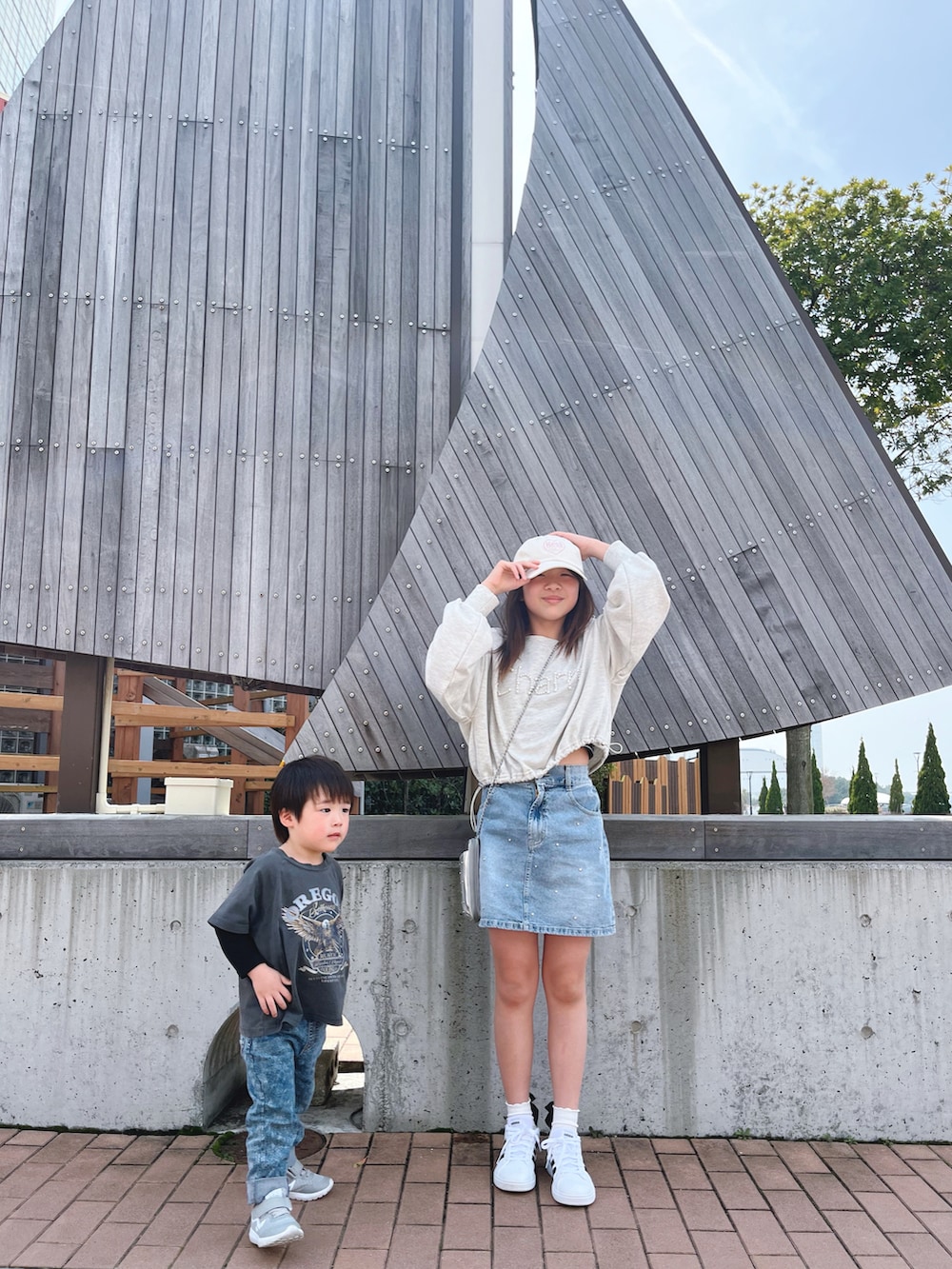 ホワイト系のトップス、ブルー系のスカート、シルバー系のバッグを着用したキッズの春コーディネートの5枚目の写真