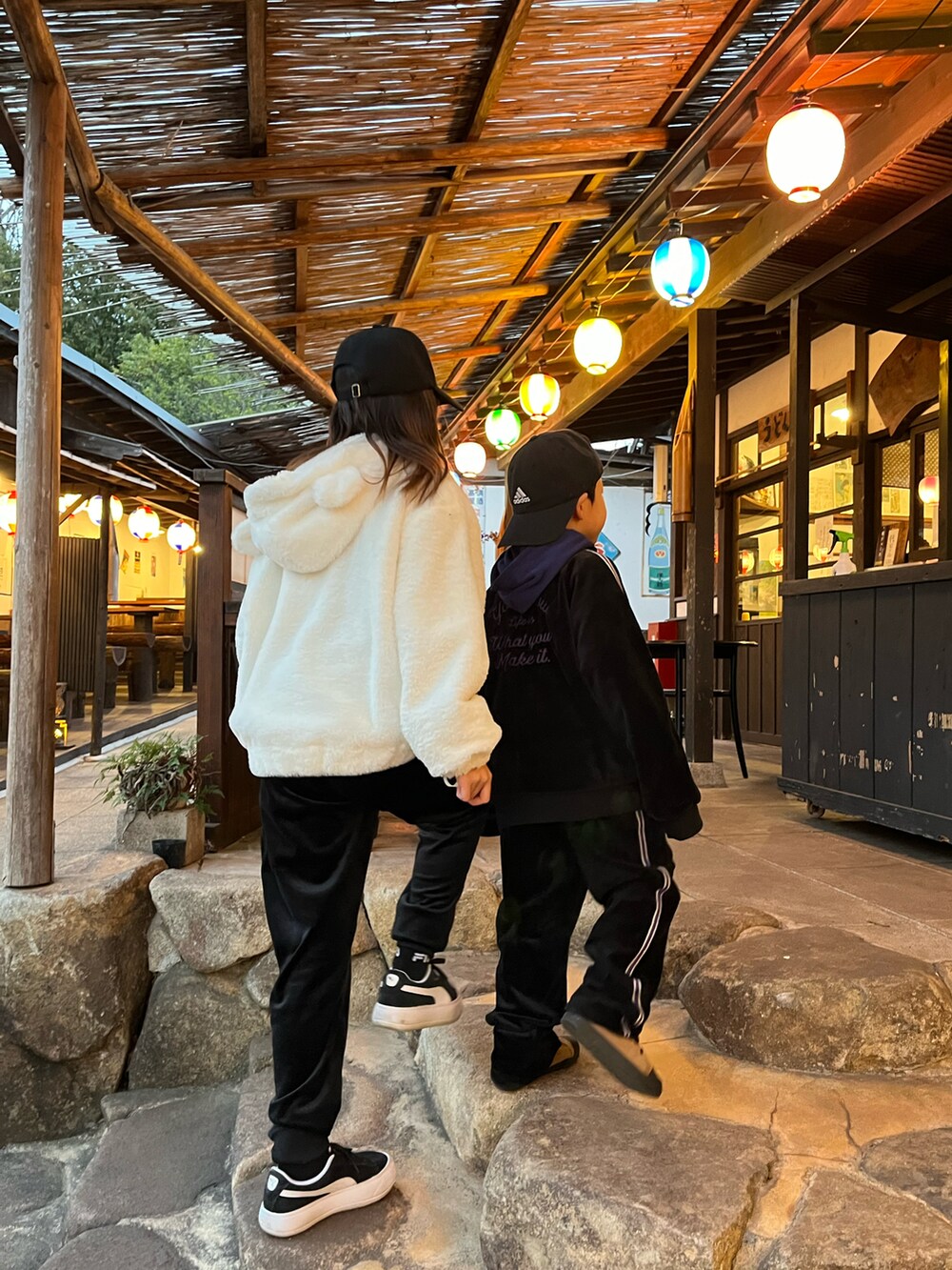 ホワイト系のジャケット/アウター、ブラック系のパンツ、ブラック系のスニーカーを着用したキッズの冬コーディネートの5枚目の写真