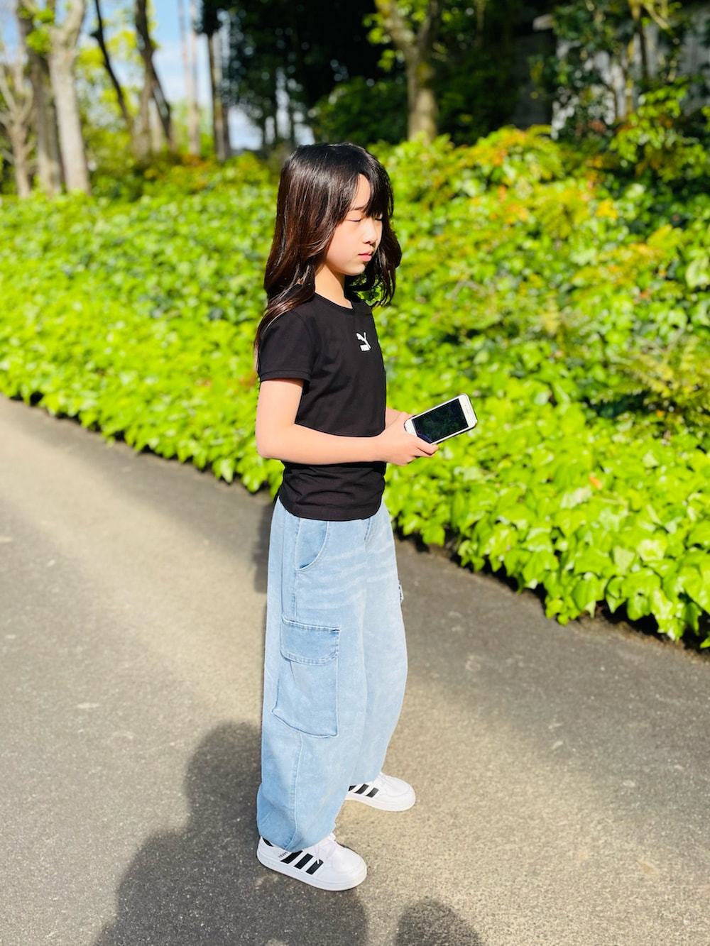 ブラック系のTシャツ/カットソー、ブルー系のカーゴパンツ、ホワイト系のスニーカーを着用したキッズの春コーディネートの3枚目の写真