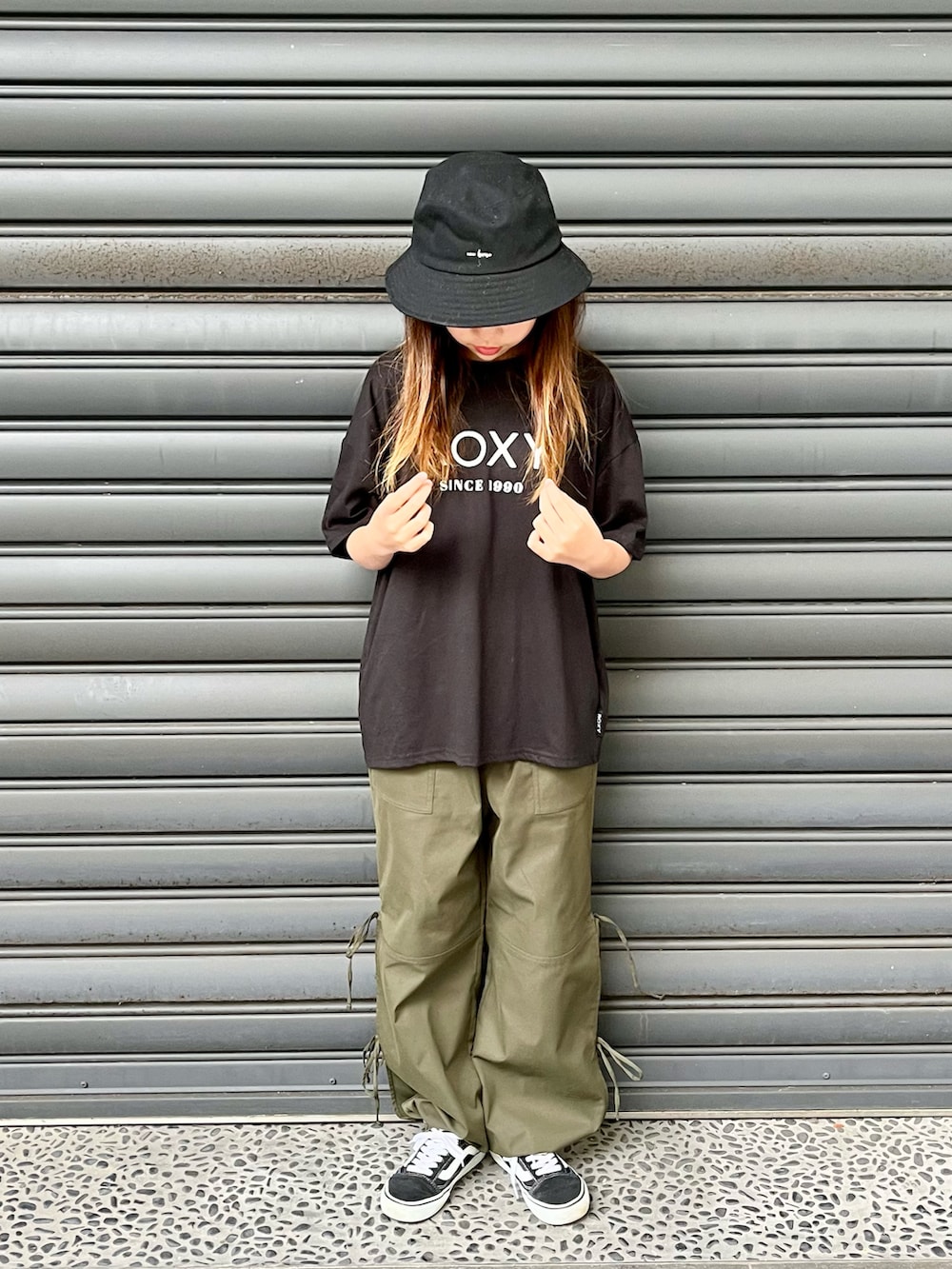 ブラック系のTシャツ/カットソー、グリーン系のカーゴパンツ、ブラック系のスニーカーを着用したキッズの春コーディネートの3枚目の写真