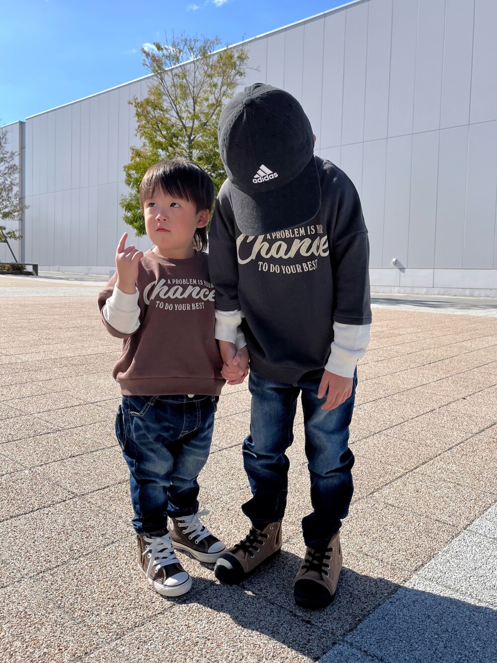 ブラック系のスウェット、ブルー系のデニムパンツ、ブラウン系のスウェットを着用したキッズの秋コーディネートの3枚目の写真