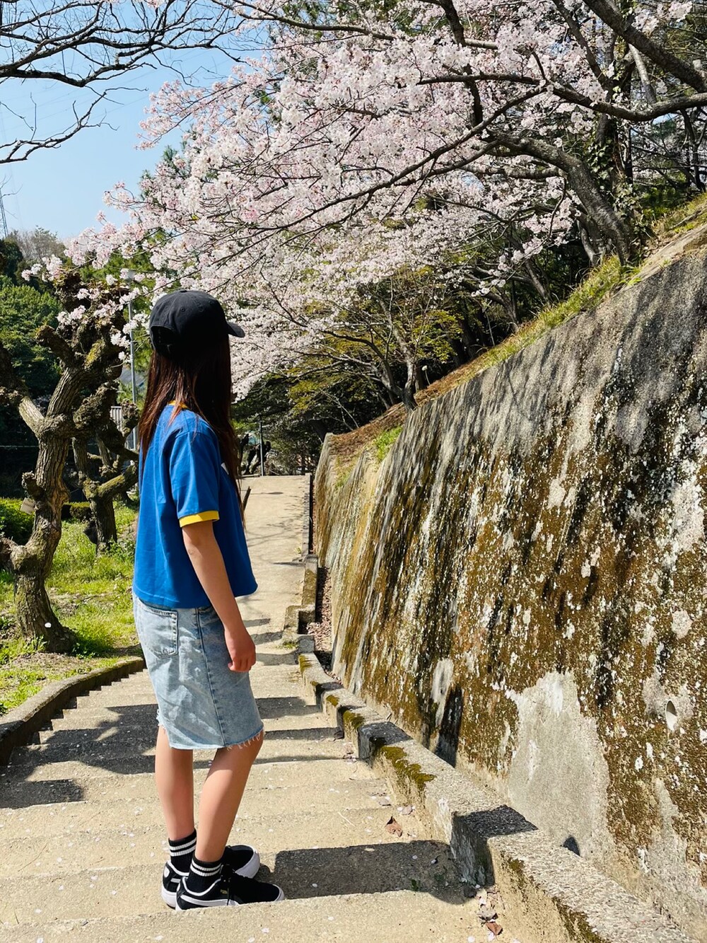 ブルー系のTシャツ/カットソー、ブラック系のスニーカー、ブルー系のパンツを着用したキッズの春コーディネートの2枚目の写真