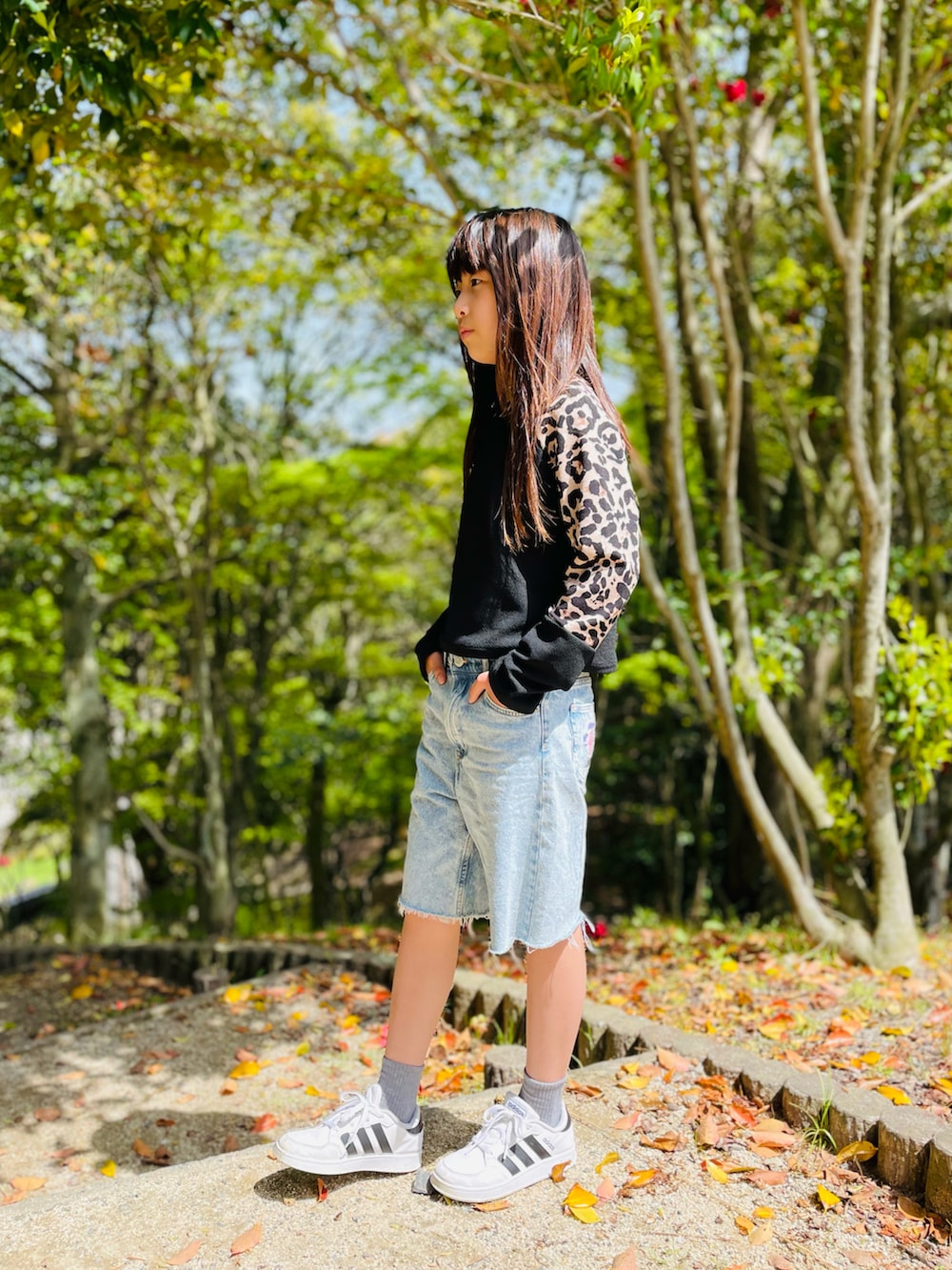 ブラック系のトップス、ブルー系のパンツ、ホワイト系のスニーカーを着用したキッズの春コーディネートの2枚目の写真