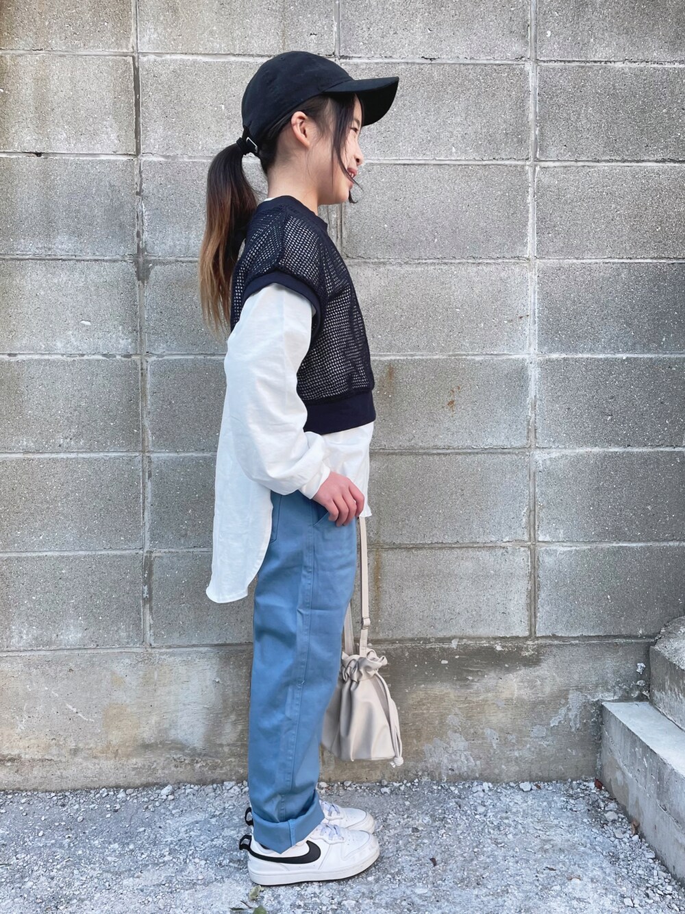 ブルー系のチノパンツ、ホワイト系のスニーカー、ホワイト系のショルダーバッグを着用したキッズの冬コーディネートの3枚目の写真