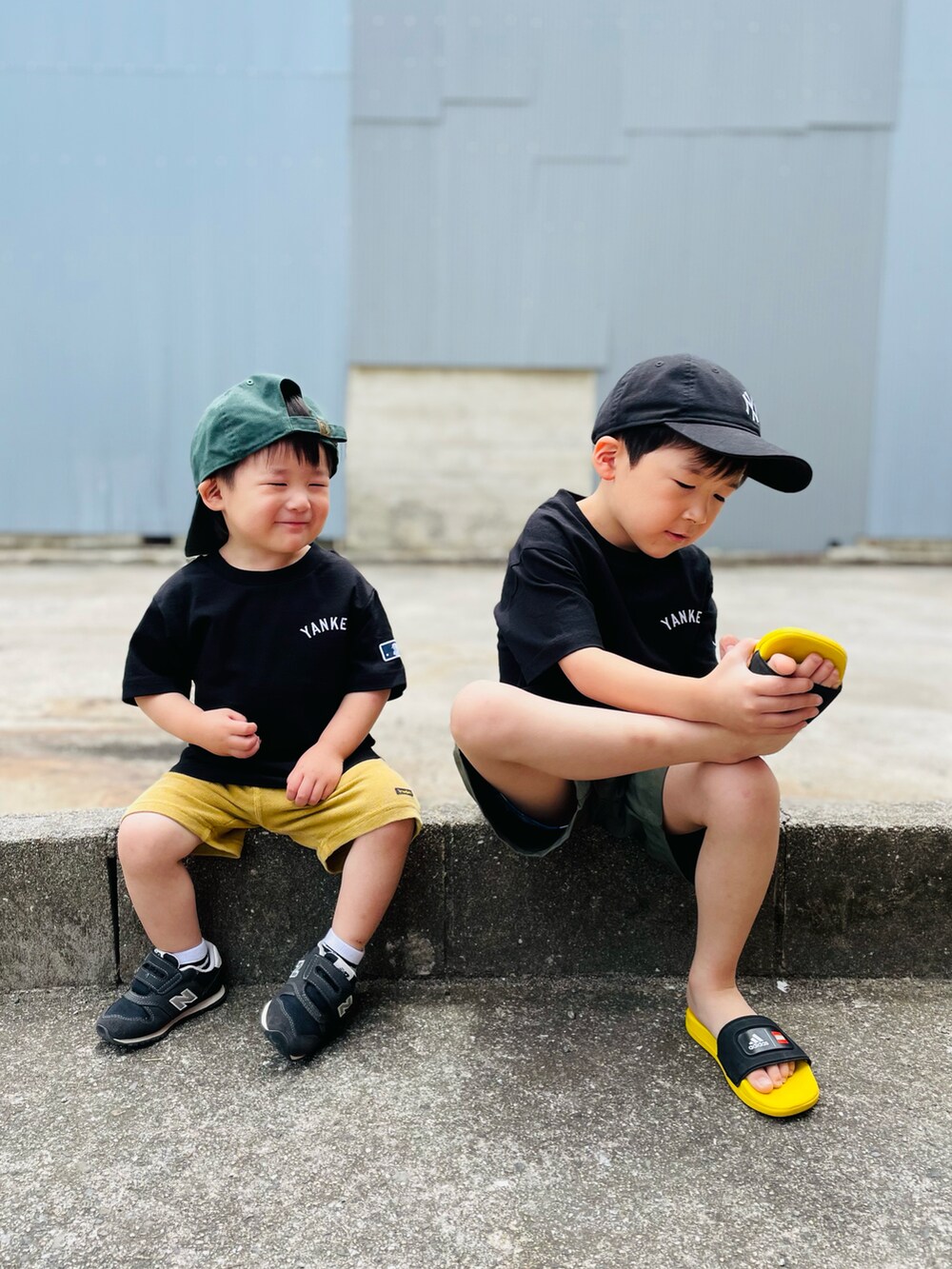 ブラック系のTシャツ/カットソー、ブラック系のサンダル、グリーン系のパンツを着用したキッズの春コーディネートの4枚目の写真
