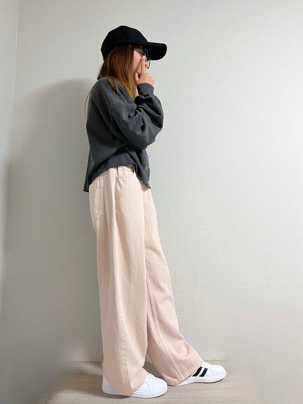 グレー系のトップス、ピンク系のデニムパンツ、ホワイト系のスニーカーを着用したキッズの冬コーディネートの3枚目の写真