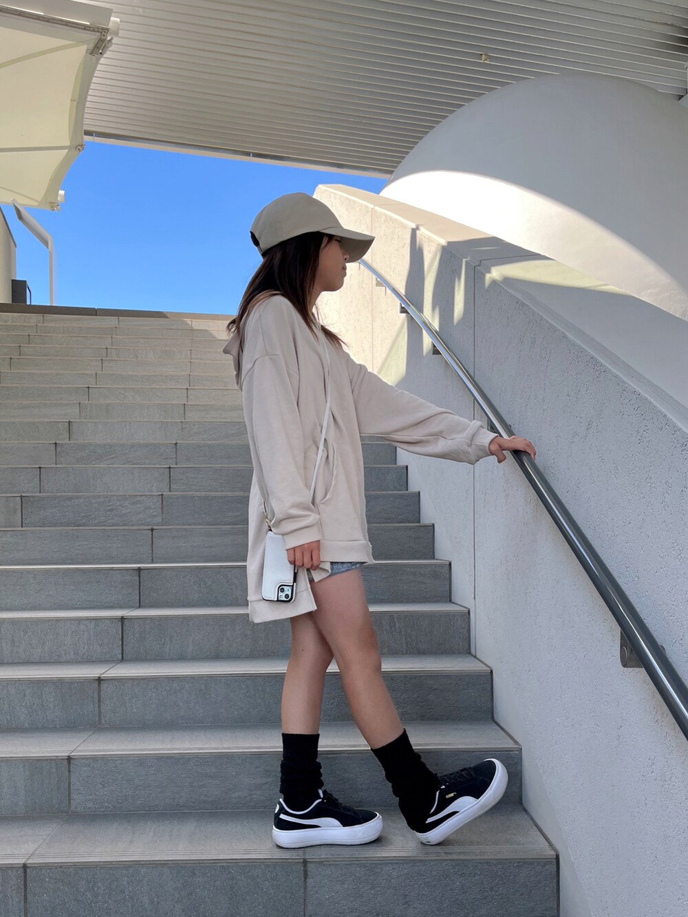 ベージュ系のスウェット、ブルー系のパンツ、ブラック系のスニーカーを着用したキッズの秋コーディネートの2枚目の写真