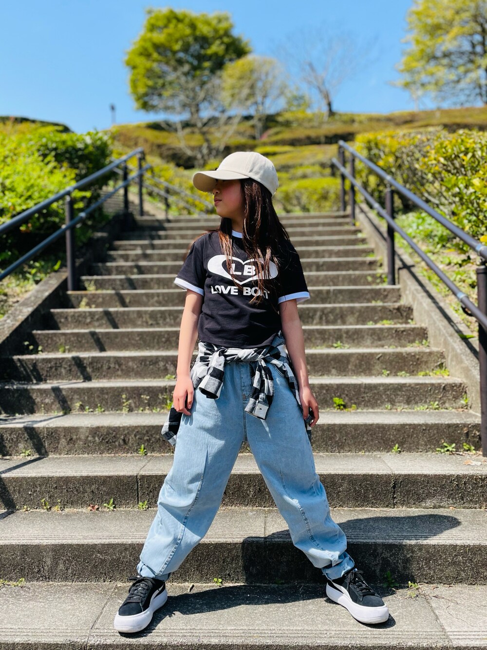 ブラック系のTシャツ/カットソー、ブルー系のパンツ、ブラック系のスニーカーを着用したキッズの春コーディネートの2枚目の写真