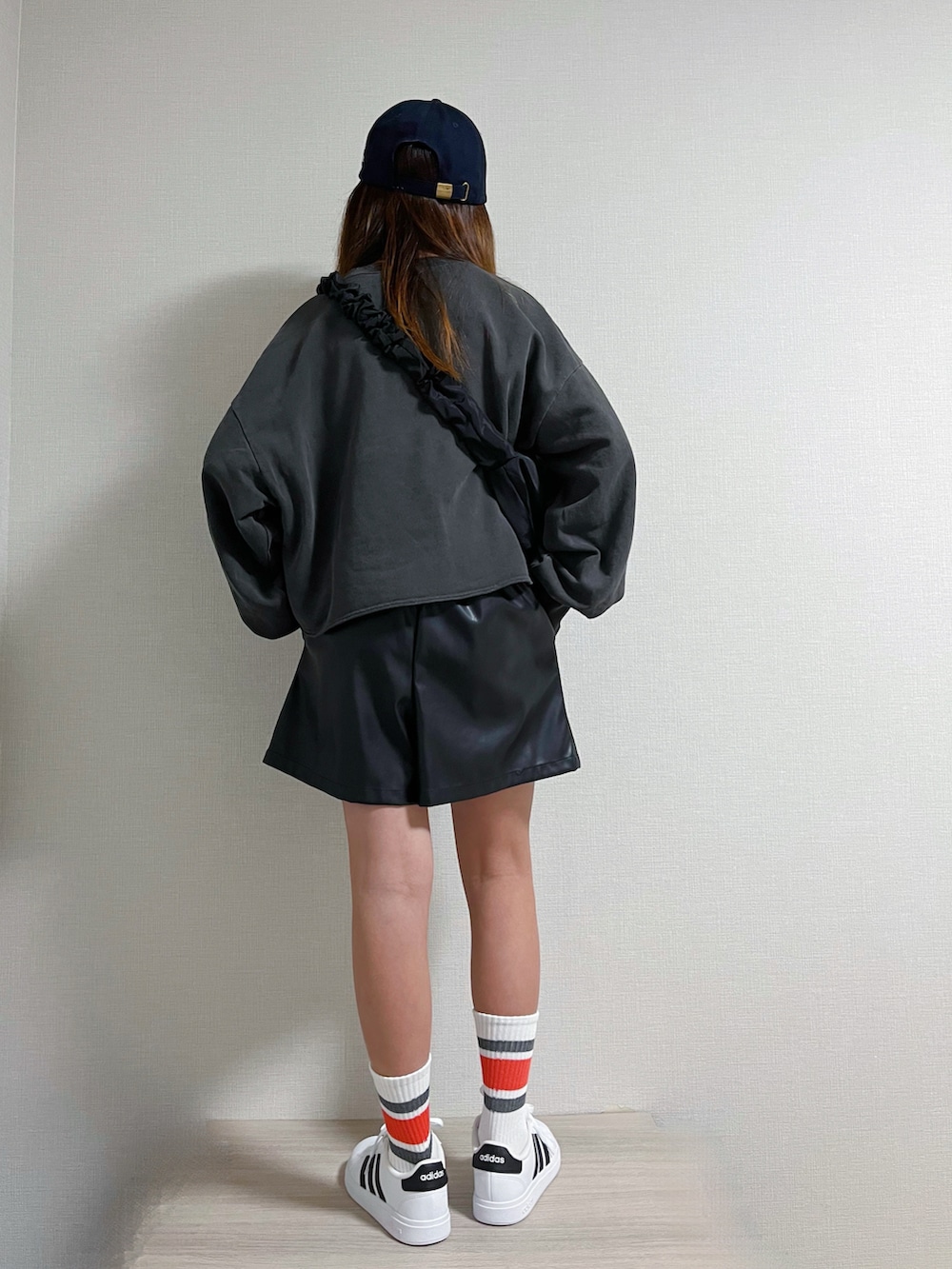 ブラック系のショルダーバッグ、グレー系のトップス、ブラック系のパンツを着用したキッズの冬コーディネートの3枚目の写真