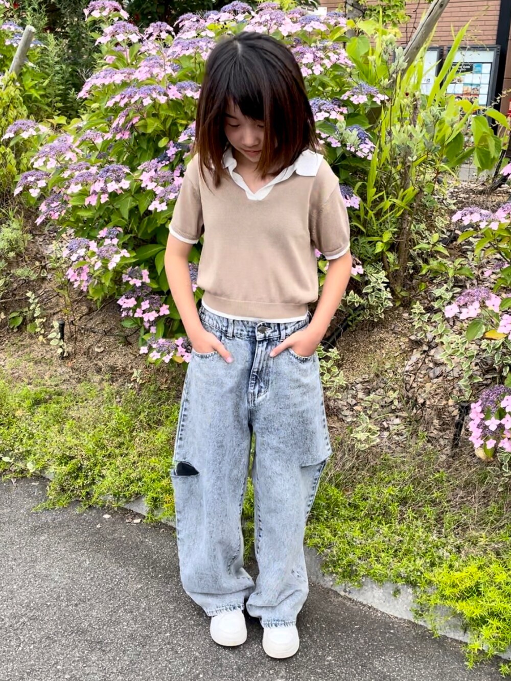 ベージュ系のトップス、ブルー系のデニムパンツ、ブラック系のサンダルを着用したキッズの夏コーディネートの3枚目の写真