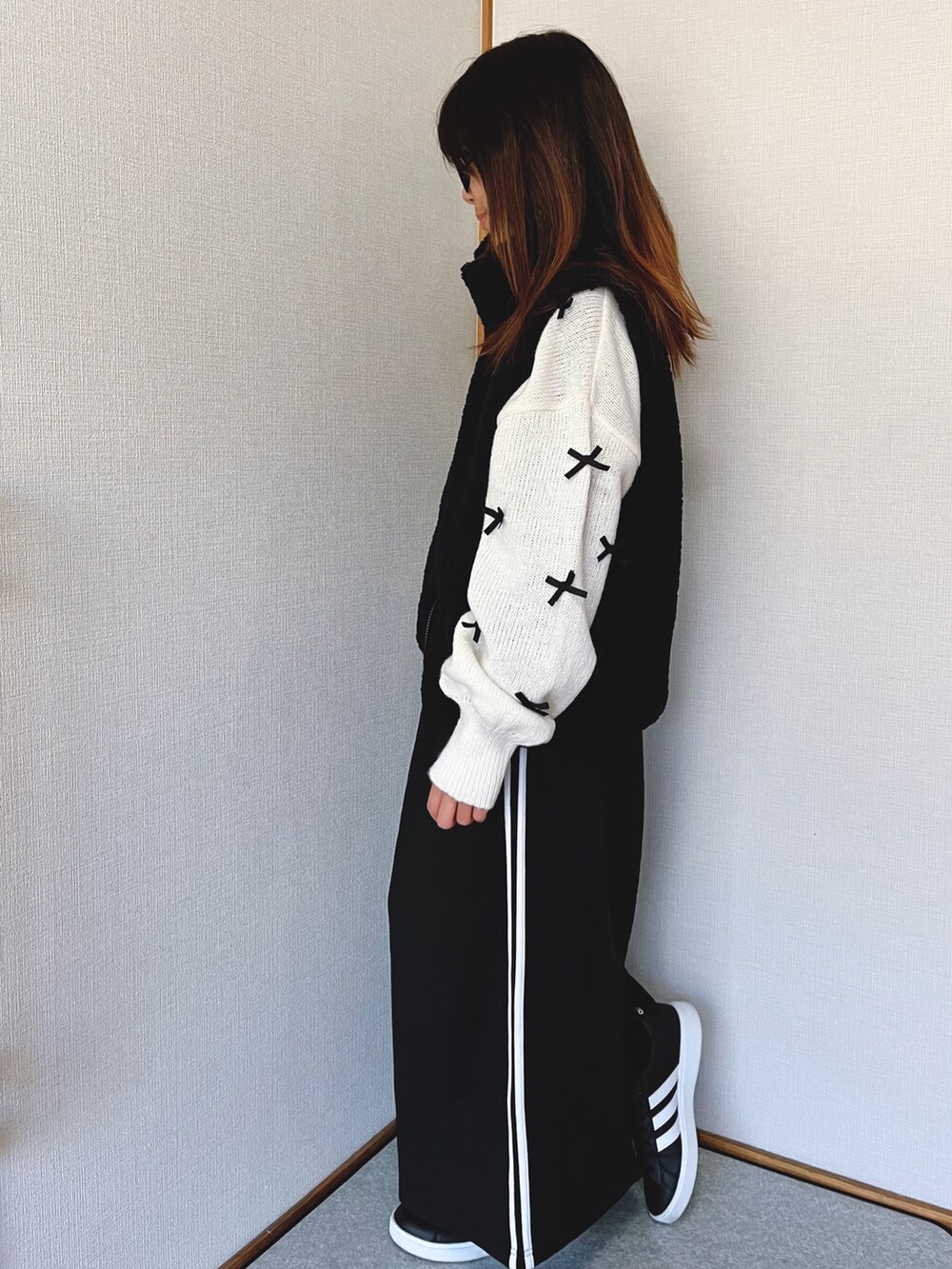 ホワイト系のニット/セーター、ブラック系のスカート、ブラック系のベストを着用したキッズの冬コーディネートの3枚目の写真