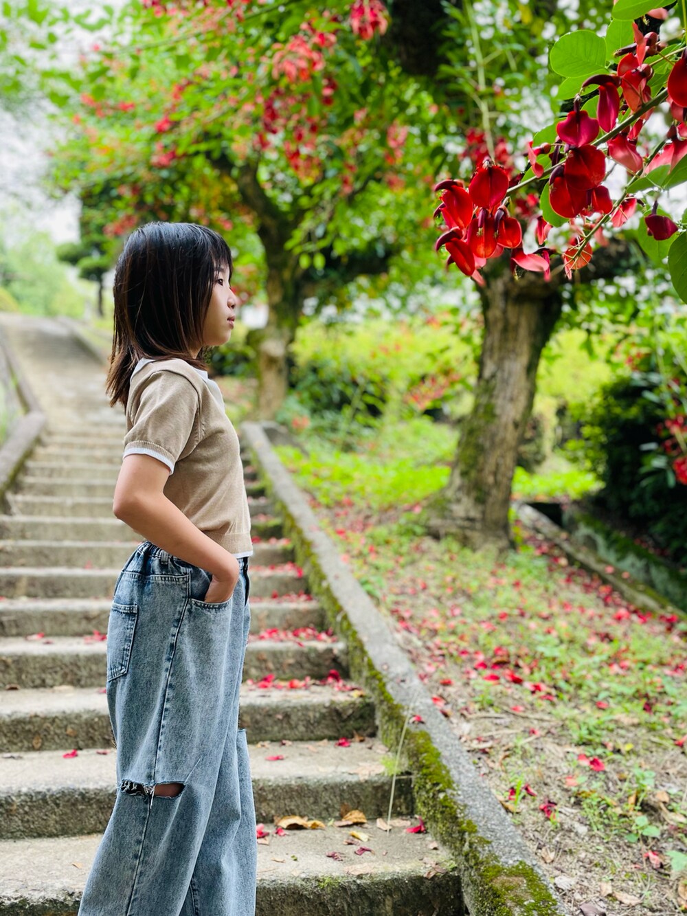 ベージュ系のトップス、ブルー系のデニムパンツ、ブラック系のサンダルを着用したキッズの夏コーディネートの2枚目の写真