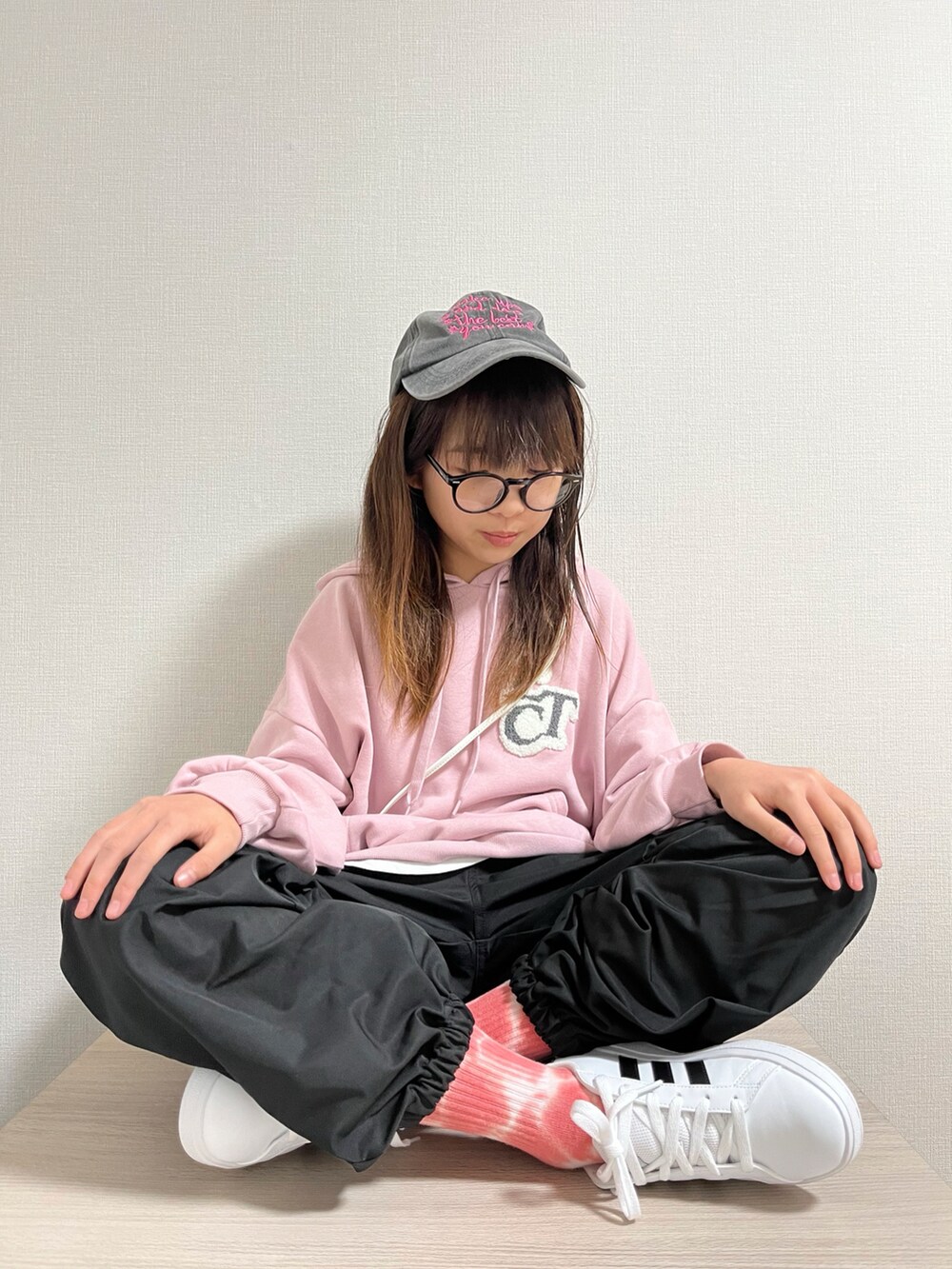 ピンク系のパーカー、ブラック系のカーゴパンツ、ホワイト系のショルダーバッグを着用したキッズの冬コーディネートの2枚目の写真