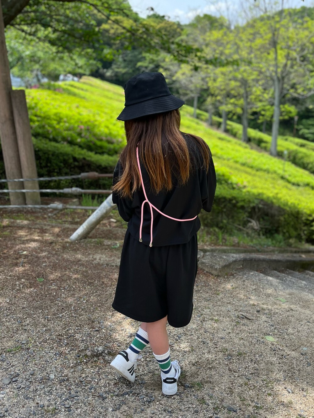 ブラック系のセットアップ、ホワイト系のスニーカー、ブラック系のハットを着用したキッズの春コーディネートの2枚目の写真