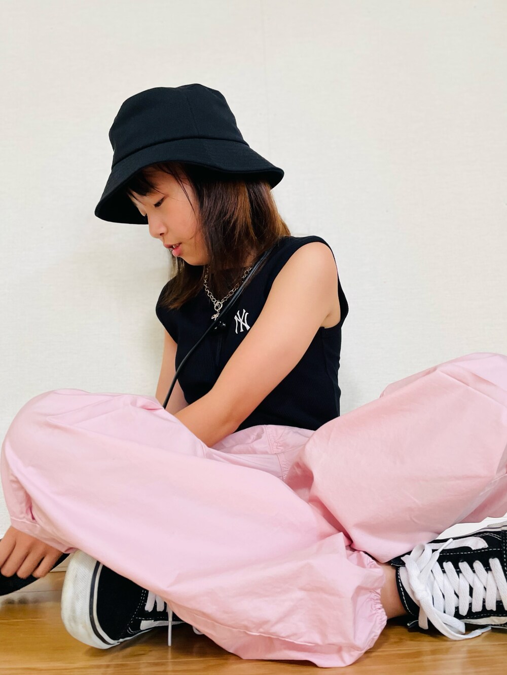 ブラック系のトップス、ピンク系のカーゴパンツ、ブラック系のスニーカーを着用したキッズの夏コーディネートの2枚目の写真