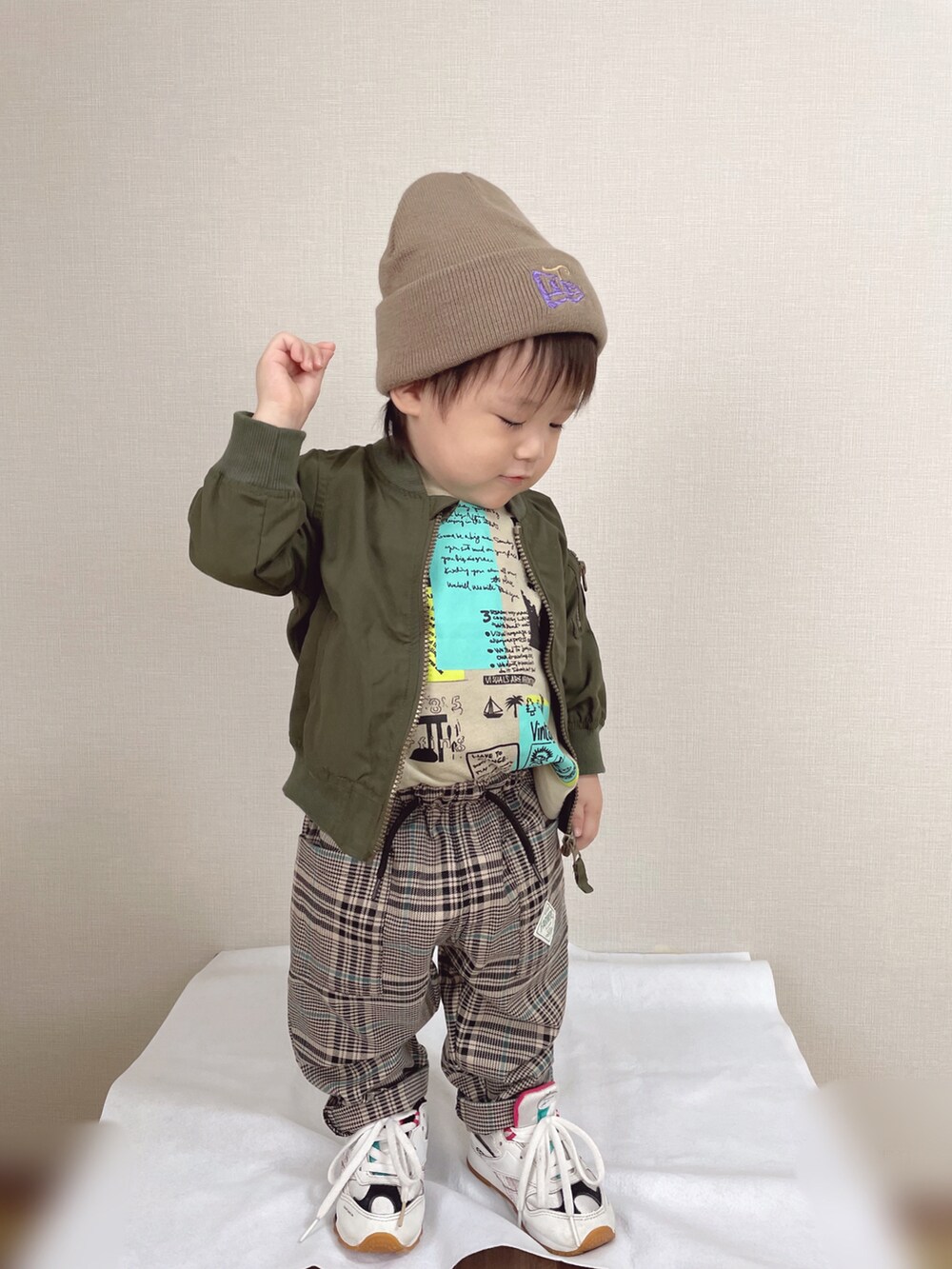 グリーン系のMA-1、ベージュ系のTシャツ/カットソー、ブラウン系のパンツを着用したキッズの秋コーディネートの2枚目の写真