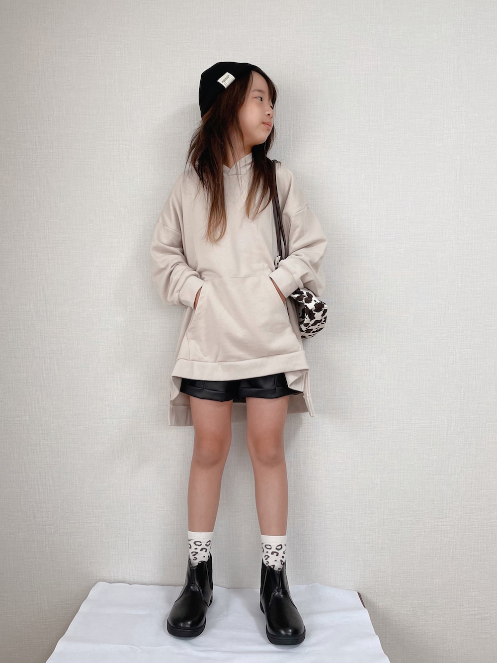 ベージュ系のスウェット、ブラック系のブーツ、ブラック系のパンツを着用したキッズの秋コーディネートの2枚目の写真