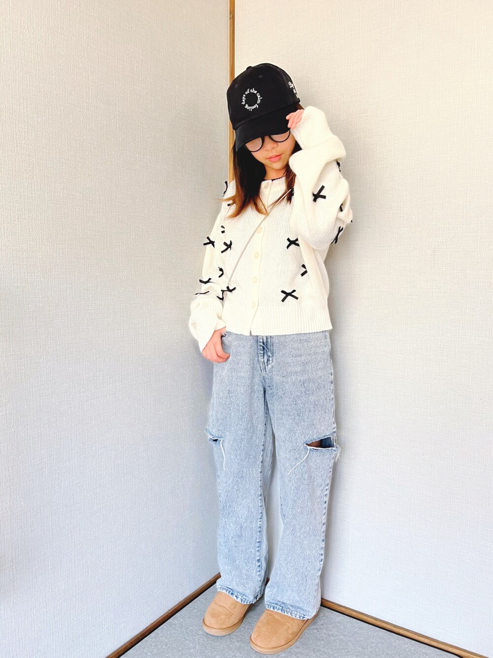 ホワイト系のニット/セーター、ホワイト系のジャケット/アウター、ブルー系のデニムパンツを着用したキッズの冬コーディネートの3枚目の写真