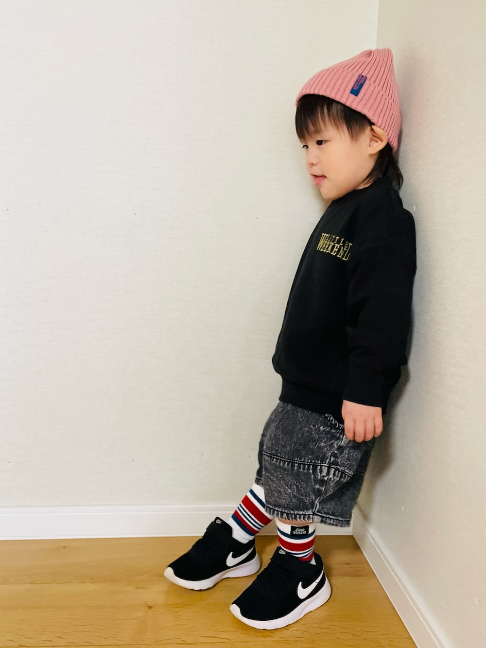 ブラック系のスウェット、ピンク系のニットキャップ/ビーニー、ホワイト系のソックス/靴下を着用したキッズの秋コーディネートの2枚目の写真