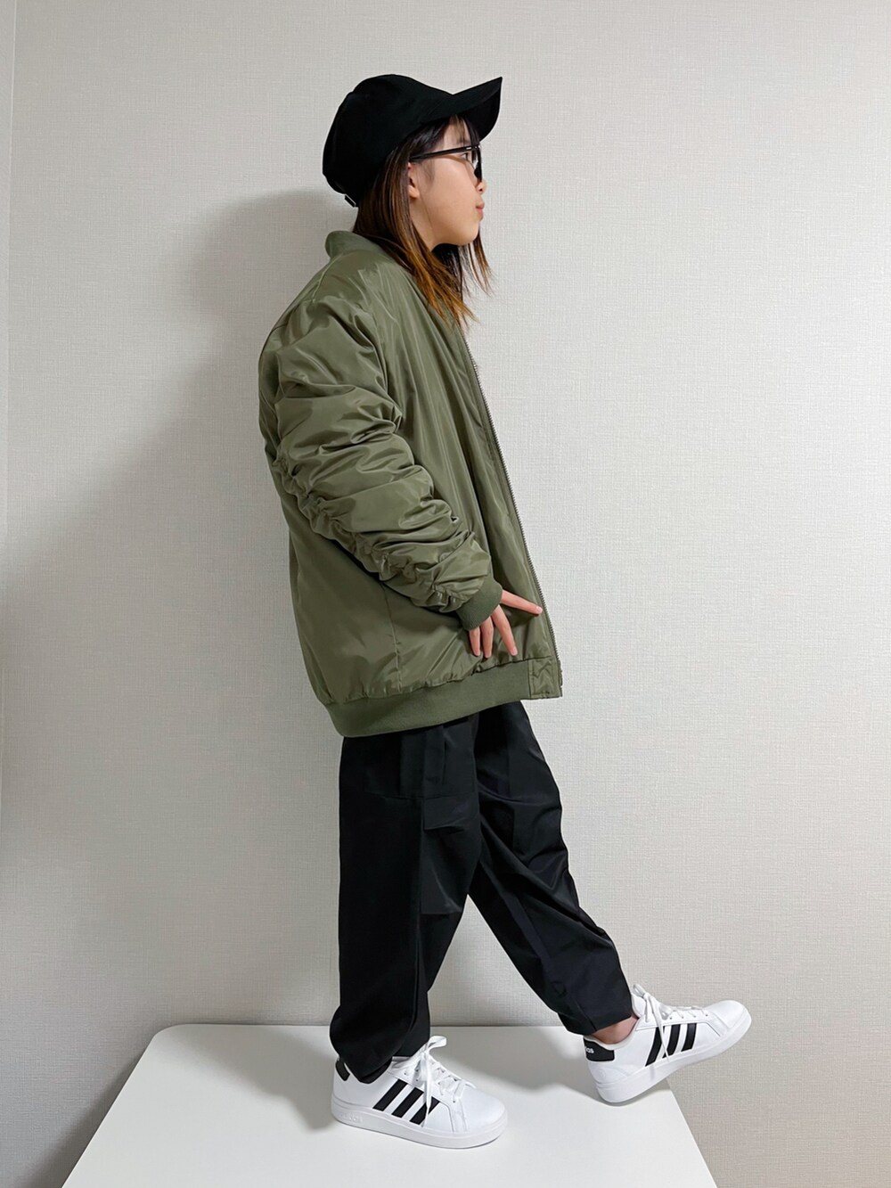 ブラック系のカーゴパンツ、ホワイト系のスニーカー、ブラック系のキャップを着用したキッズの冬コーディネートの2枚目の写真