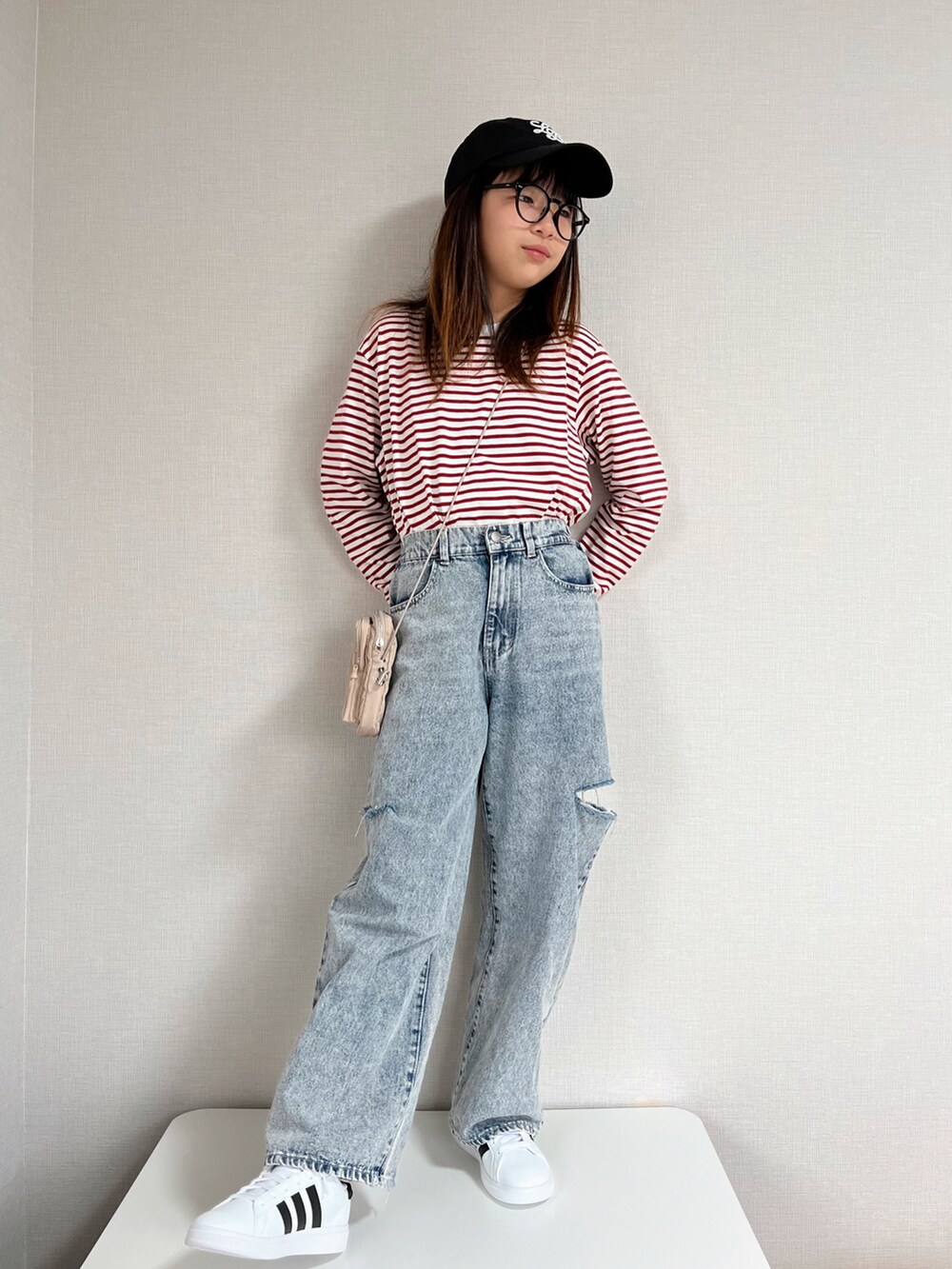 レッド系のTシャツ/カットソー、ブルー系のデニムパンツ、ベージュ系のショルダーバッグを着用したキッズの冬コーディネートの4枚目の写真