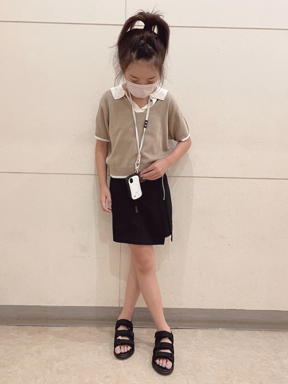 ベージュ系のトップス、ブラック系のパンツ、ブラック系のサンダルを着用したキッズの夏コーディネートの4枚目の写真