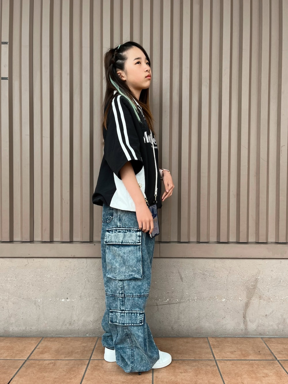 ブラック系のトップス、ブルー系のカーゴパンツを着用したキッズの春コーディネートの2枚目の写真