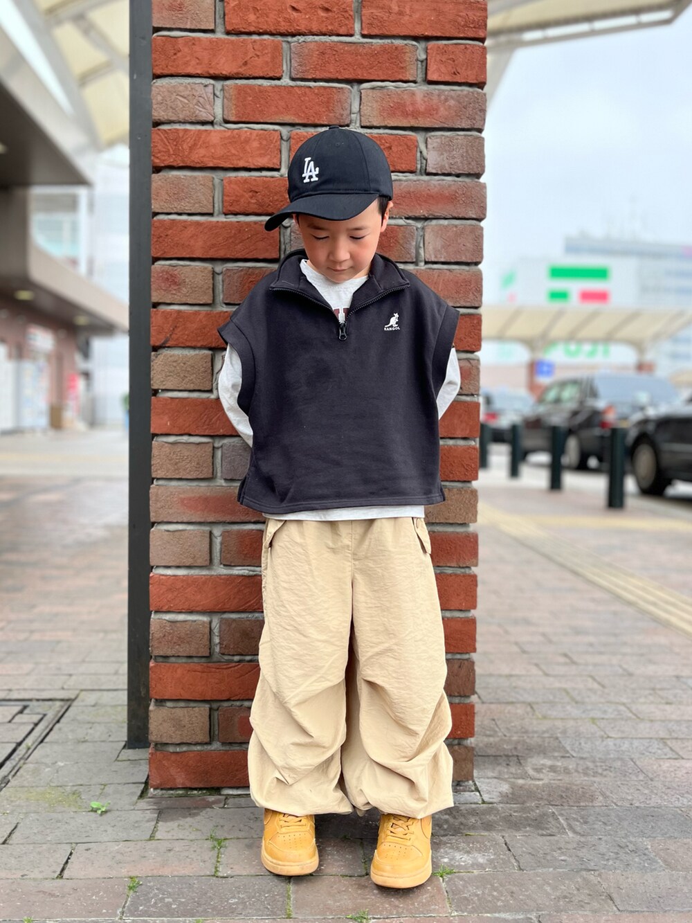 ベージュ系のカーゴパンツ、ブラック系のキャップを着用したキッズの春コーディネートの2枚目の写真