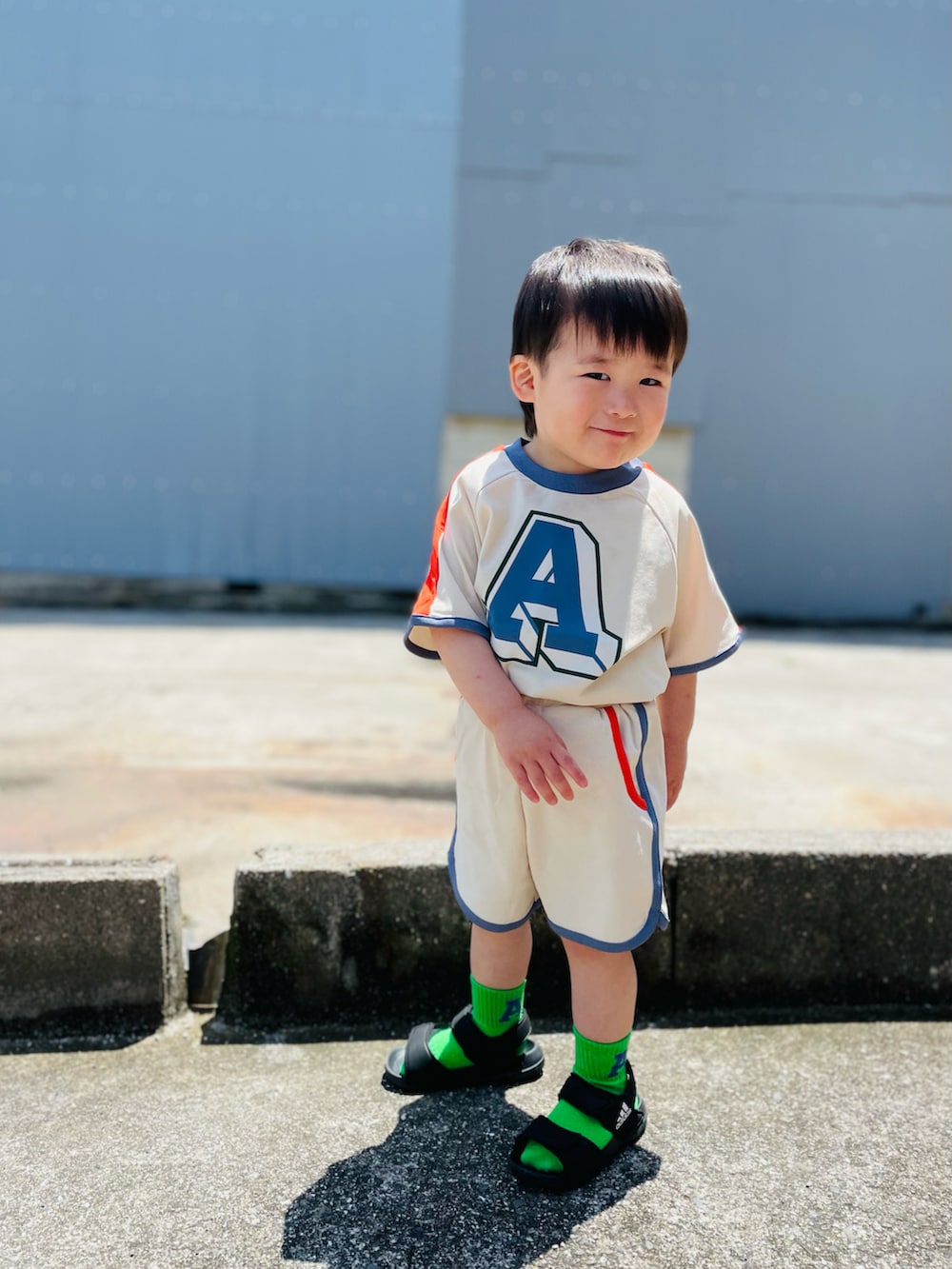 ホワイト系のTシャツ/カットソー、ホワイト系のその他パンツ、オレンジ系のソックス/靴下を着用したキッズの春コーディネートの2枚目の写真
