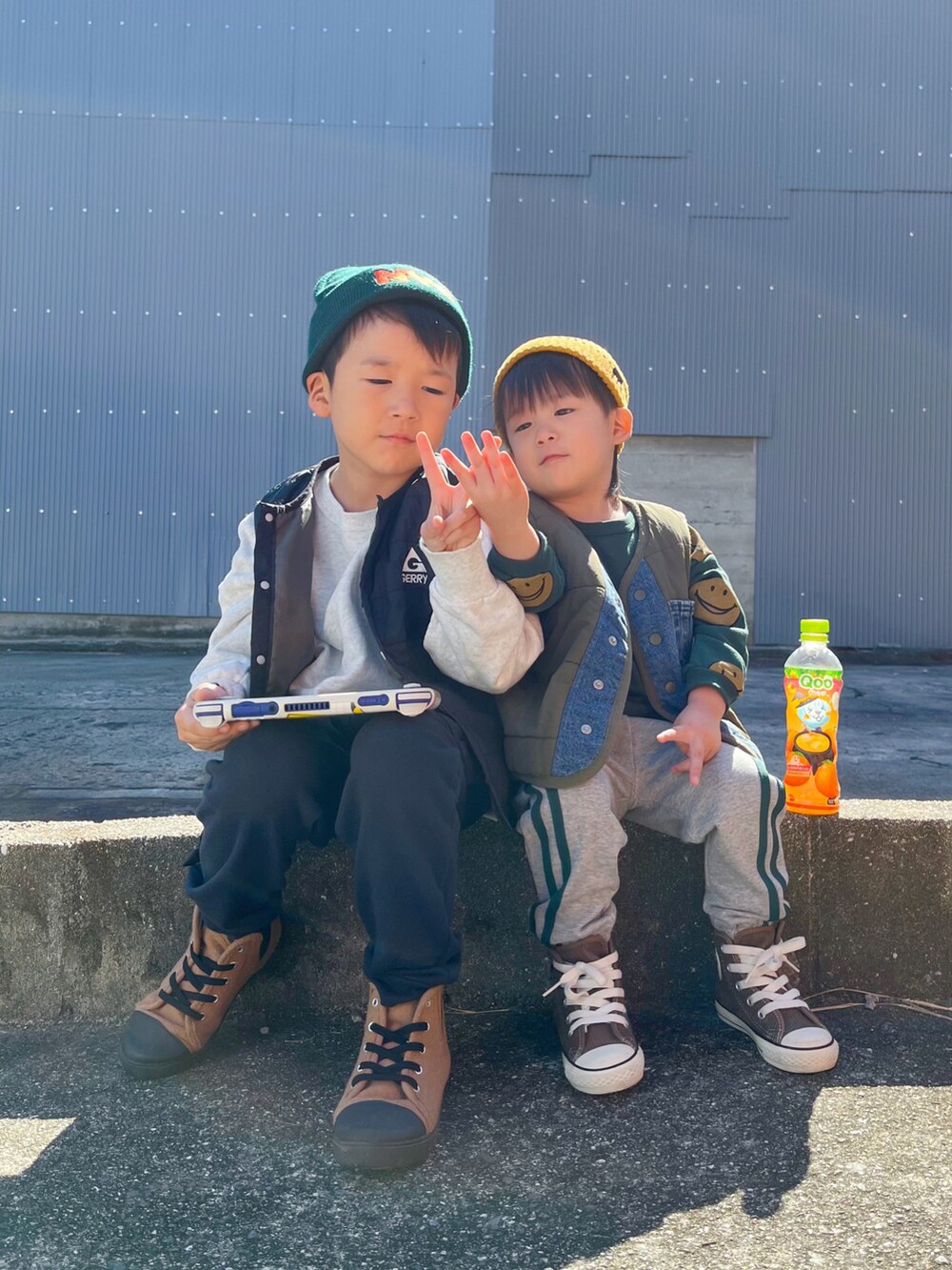 ブラウン系のスニーカー、ブラック系のベスト、グレー系のスウェットを着用したキッズの秋コーディネートの2枚目の写真