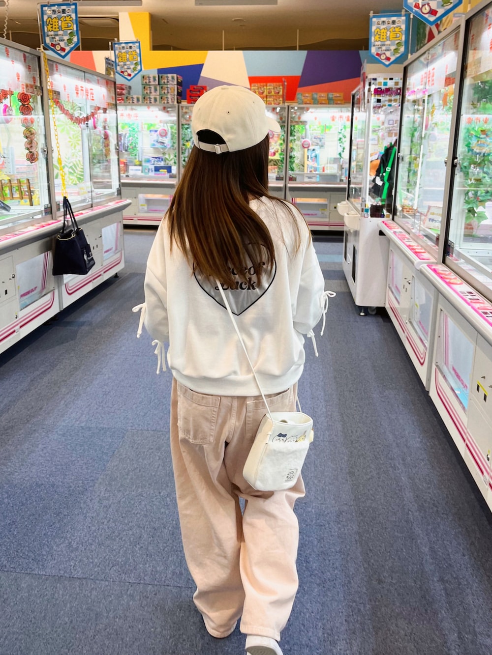 ホワイト系のトップス、ピンク系のデニムパンツ、ホワイト系のショルダーバッグを着用したキッズの春コーディネートの5枚目の写真