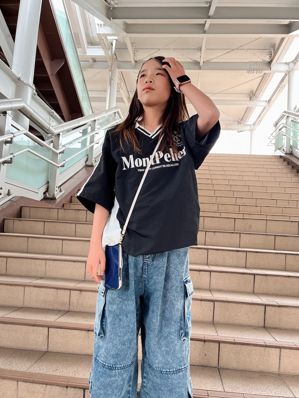 ブラック系のトップス、ブルー系のカーゴパンツを着用したキッズの春コーディネートの3枚目の写真